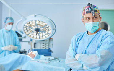 Several doctors surrounding patient on operation table during t