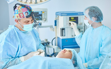 Several doctors surrounding patient on operation table during t