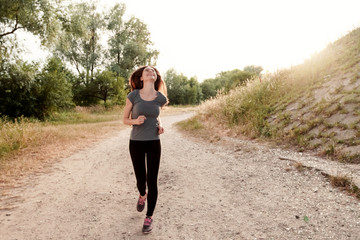 Girl with long hair runs around at sunset outdoors. Concept of sport, healthy lifestyle, body care.