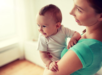 family, child and parenthood concept - close up of happy smiling young mother with little baby at home