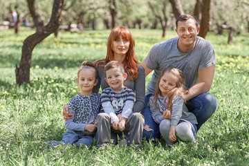 Fototapeta na wymiar parents with their children on spring garden background