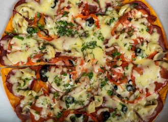 Hunting pizza with sausage, beef, tomatoes and olives