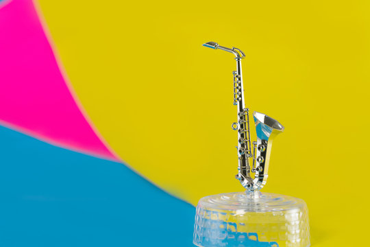 Little golden saxophone isolated on vivid background