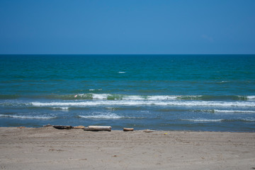 Mar azul turquesa en calma, con olas pequeñas y cielo azul despejado, con arena dorada, en las costas de Tecolutla, Veracruz