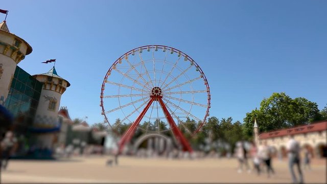 People walk around Observation Wheels. Large modern ferris wheel