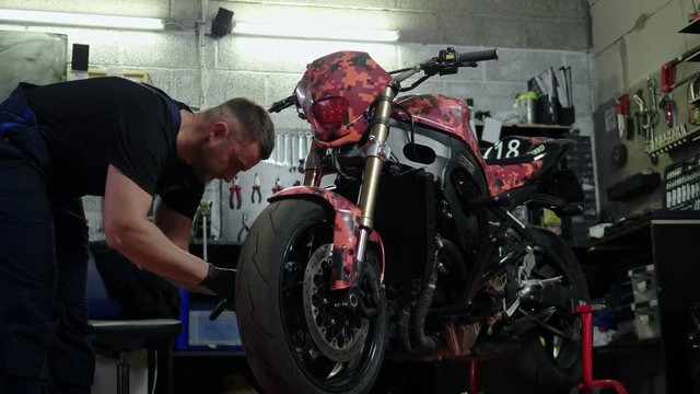 Mechanic repairing a motorcycle in a workshop
