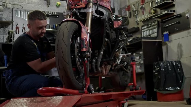 Mechanic repairing a motorcycle in a workshop