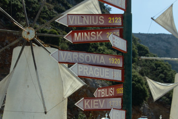 Direction sigh to different cities with mills on the background