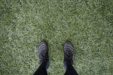 top view of leg wearing stud in the football artificial grass field in a soccer game