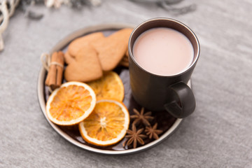 Obraz na płótnie Canvas drinks and season concept - cup of hot chocolate with dried orange, gingerbread cookies, cinnamon and anise on plate or tray