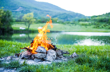 Camping with a fire in the mountains near the lake