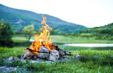 Camping with a fire in the mountains near the lake