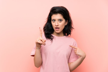 Obraz premium Young woman over isolated pink background with surprise facial expression