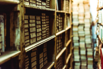 Fototapeta selective focus of retro books on wooden shelves in library obraz