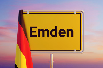 Emden. Gelbes Schild/Ortsschild. Flagge von Deutschland hängt darüber. Himmel mit Sonnenuntergang oder Sonnenaufgang