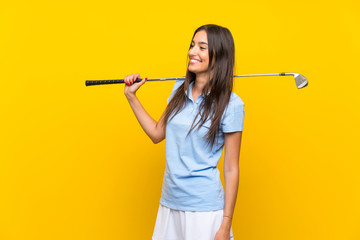 Young golfer woman over isolated yellow wall