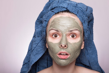 young woman in a towel on her head and mask on her face