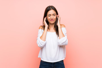 Young woman over isolated pink background frustrated and covering ears