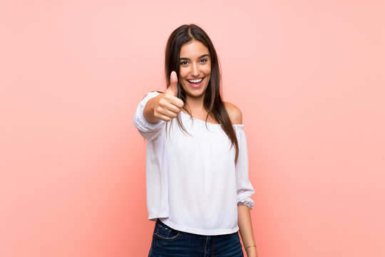 Young woman over isolated pink background with thumbs up because something good has happened