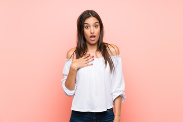 Young woman over isolated pink background surprised and shocked while looking right