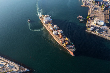 Container cargo ship leaving Long Beach harbor and heading out to the Pacific Ocean.  