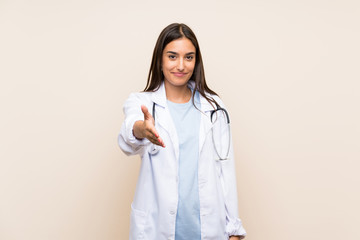 Young doctor woman over isolated background handshaking after good deal