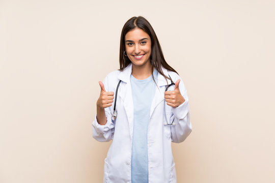Young doctor woman over isolated background giving a thumbs up gesture
