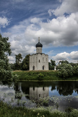Fototapeta na wymiar White stone Church of the Intercession on the Nerl with reflection in the water summer day Russia