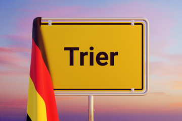 Trier. Gelbes Schild/Ortsschild. Flagge von Deutschland hängt darüber. Himmel mit Sonnenuntergang oder Sonnenaufgang
