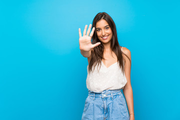 Young woman over isolated blue background counting five with fingers