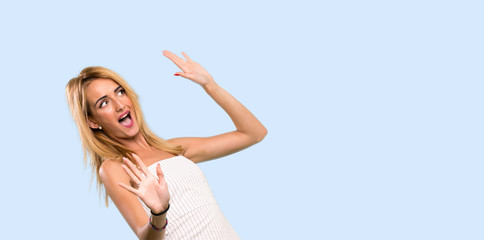 Young blonde woman nervous and scared over isolated blue background