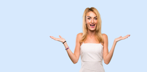 Fototapeta na wymiar Young blonde woman with shocked facial expression over isolated blue background