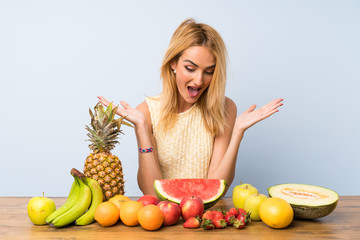 Young blonde woman with lots of fruits