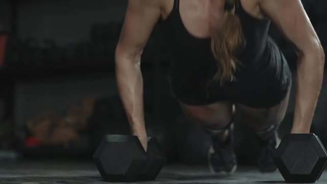 athletic beautiful girl athlete doing push ups in the gym