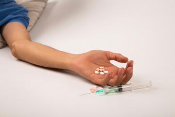 .Drug addiction concept - passive hand with coat, pills and injection, on white and isolated background