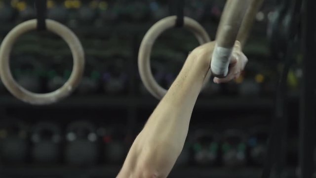 fit woman doing pull-ups on gymnastic rings workout bodybuilding - muscular bodybuilder handsome women doing exercises in gym close-up