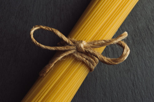 Neat rope bow on the top of uncooked pasta bunch