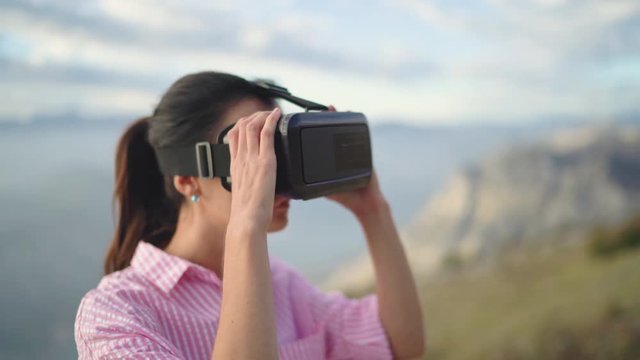 Young woman uses Virtual Reality Headset for traveling around the world