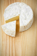camembert soft cheese on wood background 