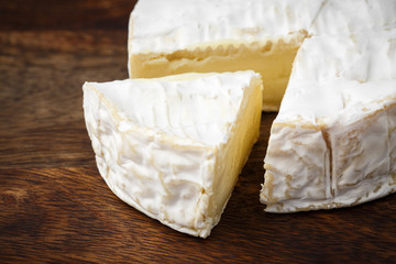camembert soft cheese on wood background 