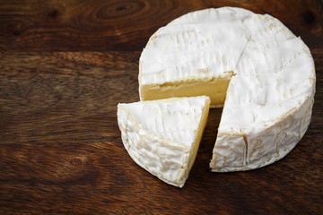 camembert soft cheese on wood background 
