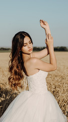 Fototapeta na wymiar Beautiful bride in wheat field on sunset