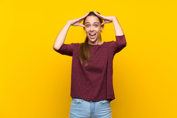 Young woman over isolated yellow background with surprise expression