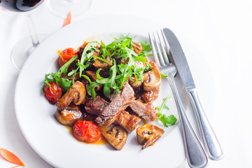 Juicy steak medium rare beef with arugula and grilled vegetables. Top view