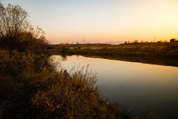 Fototapeta na wymiar View of a calm river with sunset light