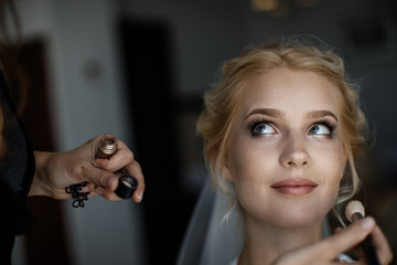 A bride is looking at the stylist. Wedding preparation concept.