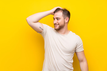 Handsome man over yellow background laughing