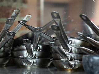 Fototapeta na wymiar Frying pans and saucepans stacked up in a restaurant kitchen. Stock Photo