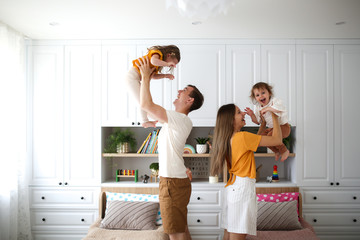 Caucasian family with two children hands in air