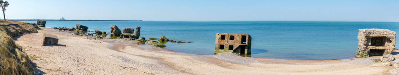 Ruins of bunkers on the beach of the Baltic sea in Liepaja, Latvia. Panorama landscape.